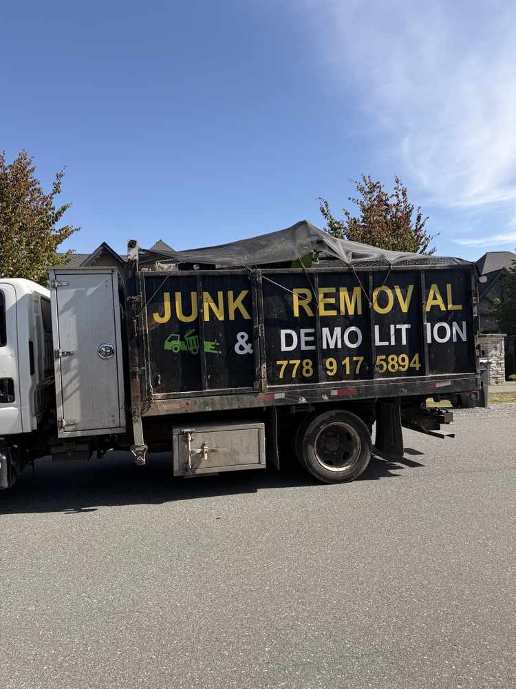 Side view of the Redtree truck showing the junk removal and demolition lettering and phone number