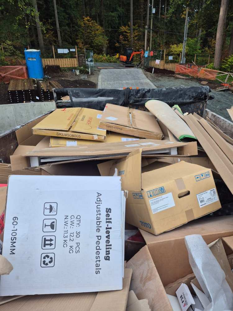 Dump truck full of cardboard boxes and packaging at a construction site